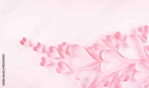 Love and Valentine's day concept. Pink paper hearts on pastel paper background. Flat lay top view with copy space.