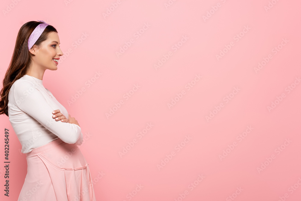 side view of young pretty pregnant woman touching belly isolated on pink side view of young pretty pregnant woman touching belly isolated on pink