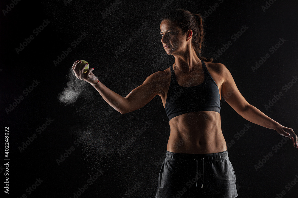Tennis player kirl with magnesium powder on her hands, grabbing a ball with dust visible Tennis player kirl with magnesium powder on her hands, grabbing a ball with dust visible