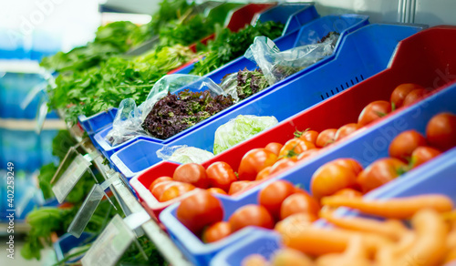 Foto Fresh loose vegetables in the aisle of the supermarket