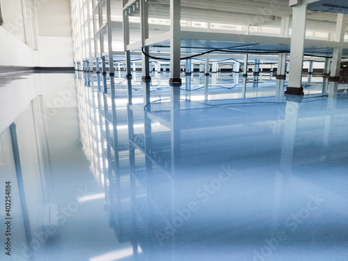 a cable under rack legs at sea blue epoxy floor. (Industrial epoxy floor)