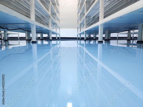a cable under rack legs at sea blue epoxy floor. (Industrial epoxy floor) © jatupron
