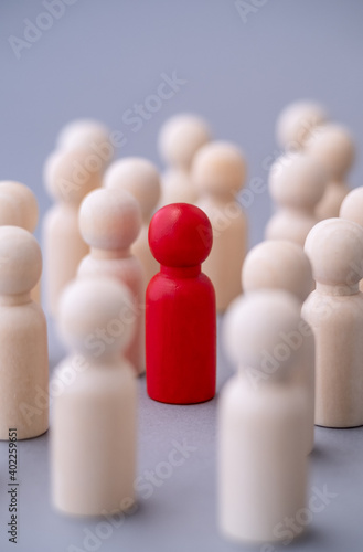 Konstfotografi Red figure of a man made of wood, standing out from the crowd of