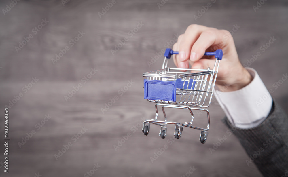Fototapeta premium Businessman holding shopping cart. Shopping