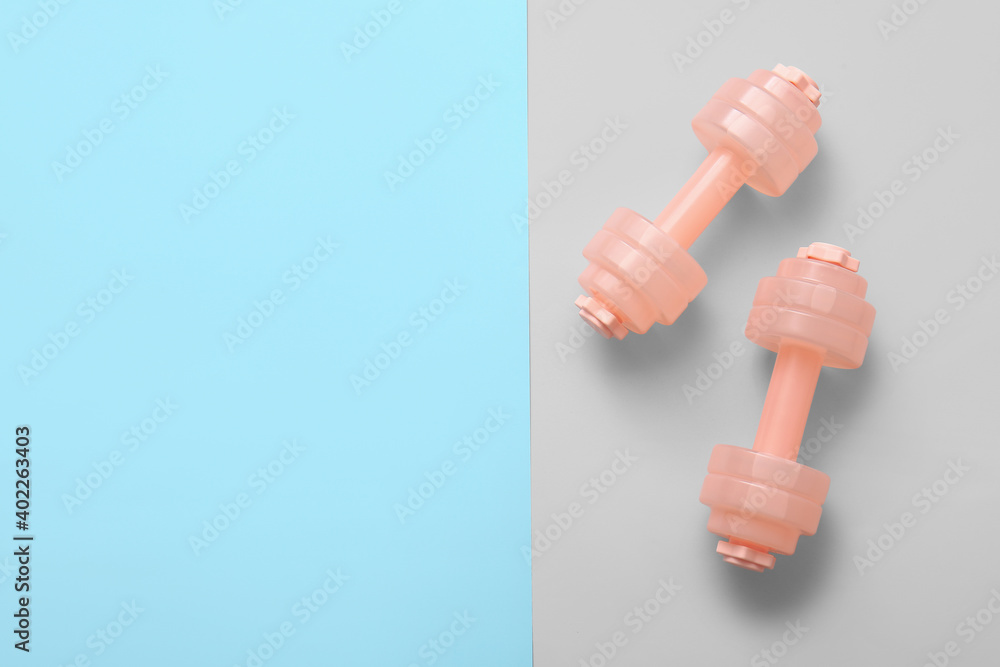 Stylish dumbbells on color background Stylish dumbbells on color background
