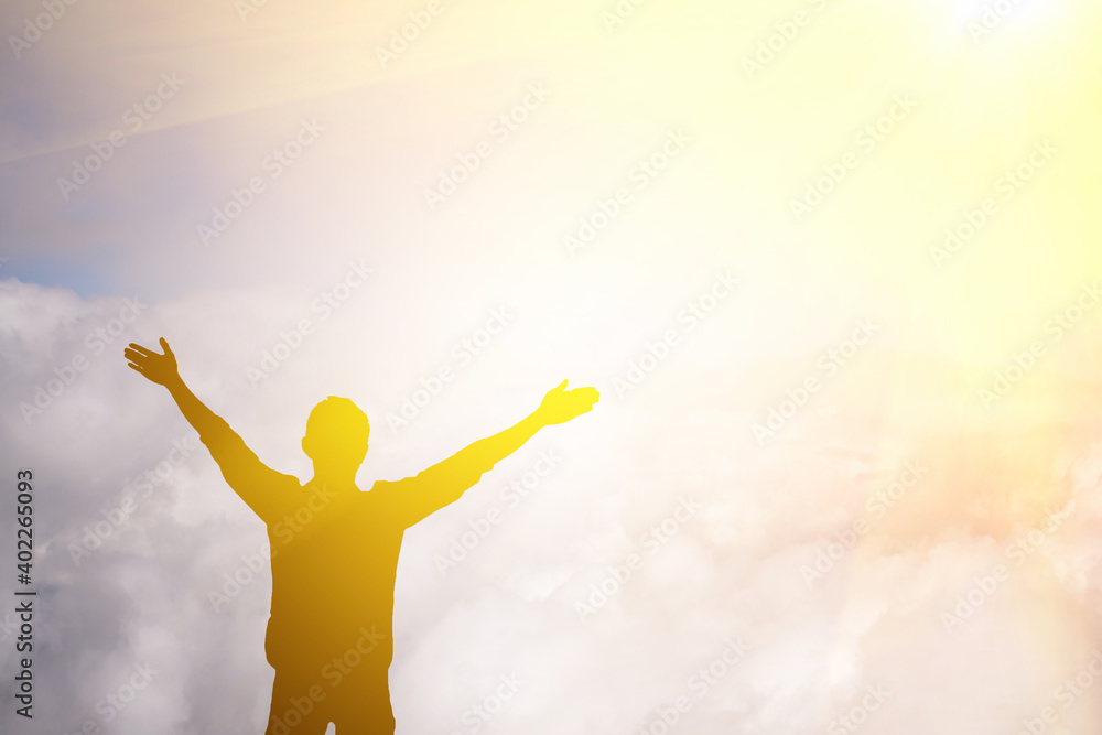 A man raised his arms to pray to God on the mountain.