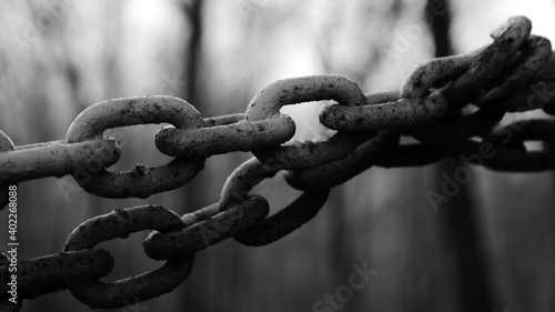 Black and white close up of think iron chains against a blurry background