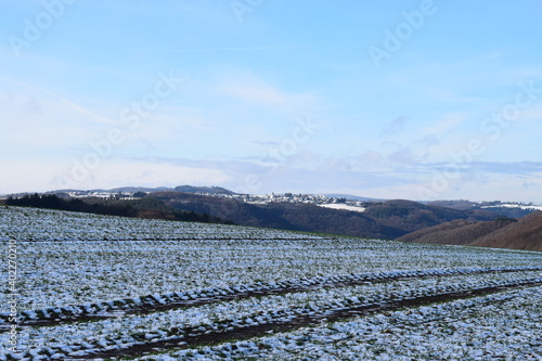 Blick über die verschneite Eifel mit dem Dorf Kirchwald photo