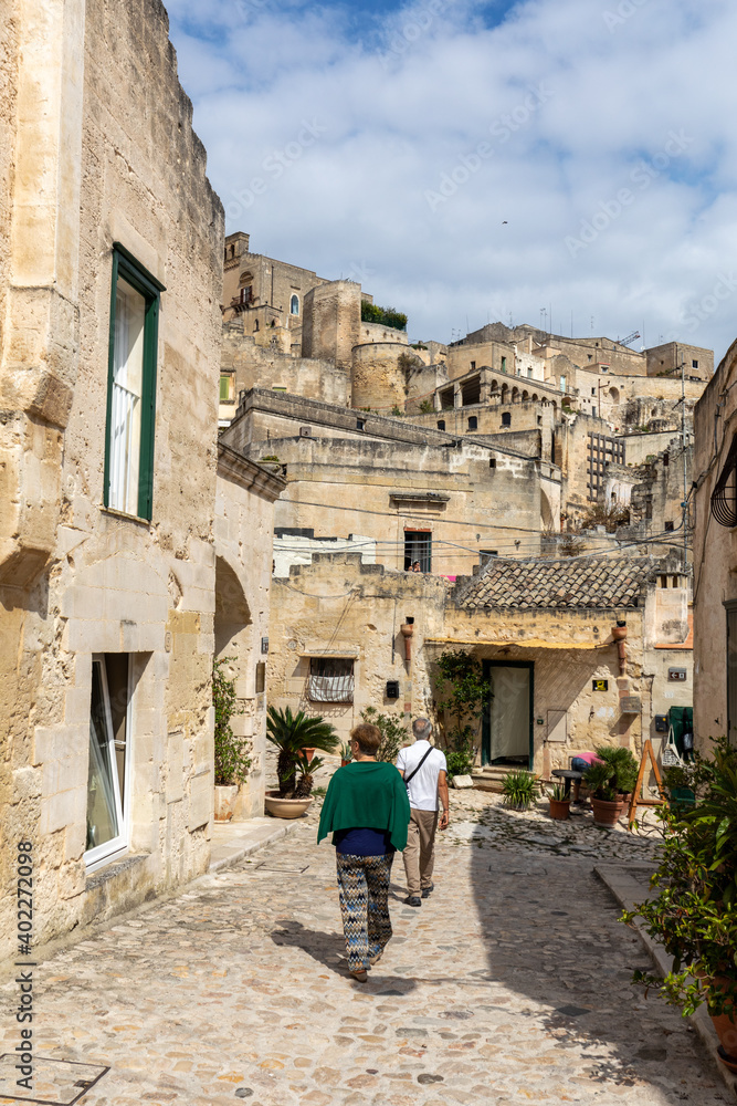 Tourists during a walk on Cobblestone street in the Sassi di Matera a historic district in the city of Matera. Basilicata. Italy