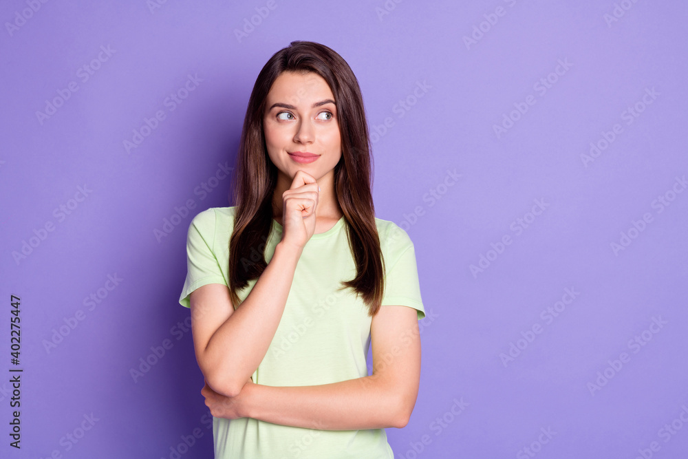 Photo portrait of curious brunette touching chin looking at blank space isolated on vivid purple color background Photo portrait of curious brunette touching chin looking at blank space isolated on vivid purple color background