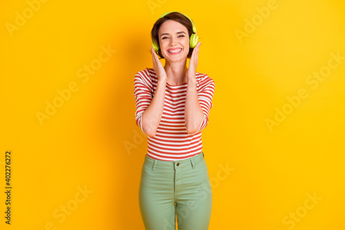 Photo of charming person listen to favorite music arms touch headphones isolated on yellow color background