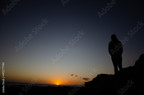 silhouette of a person on a rock © Evan