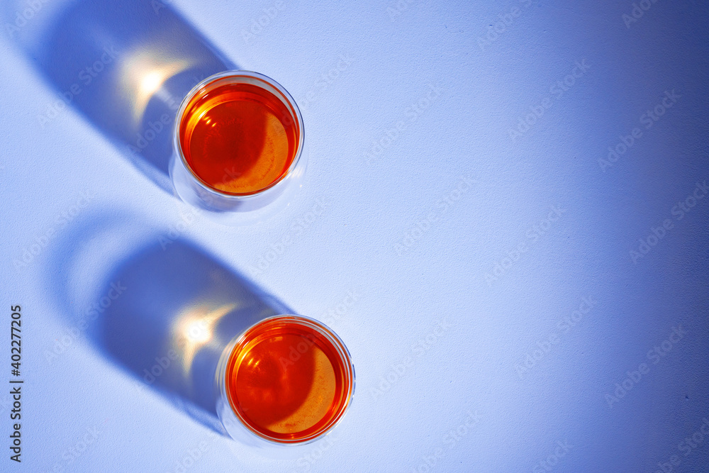 Two glass cups of tea on blue background Two glass cups of tea on blue background