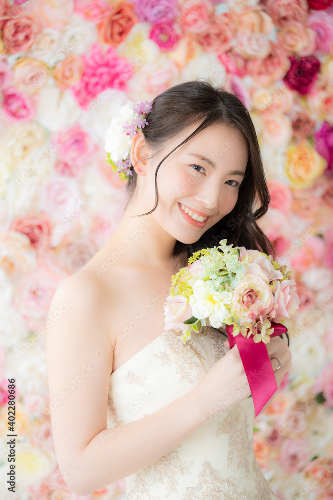 背景がバラの花でブライダルにも使えるかわいい花嫁さん8 縦向き上にコピースペースあり 背景がバラの花でブライダルにも使えるかわいい花嫁さん8 縦向き上にコピースペースあり