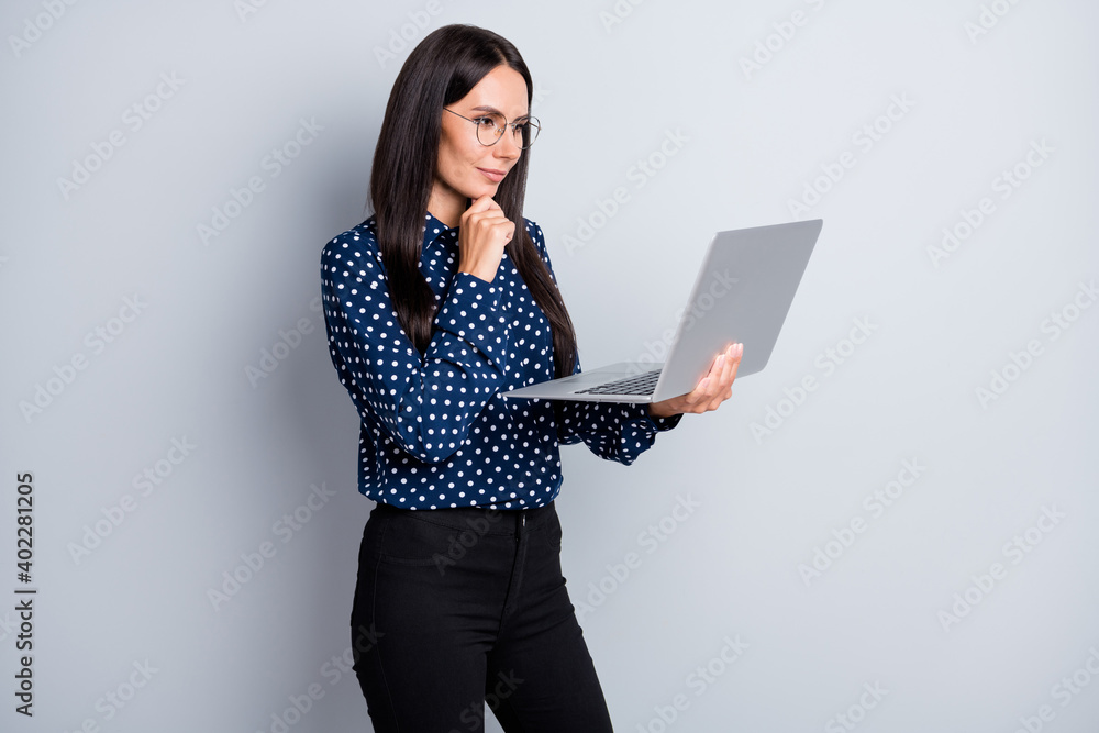 Profile side view portrait of pretty focused businesslady holding in hands laptop browsing research isolated on grey pastel color background Profile side view portrait of pretty focused businesslady holding in hands laptop browsing research isolated on grey pastel color background