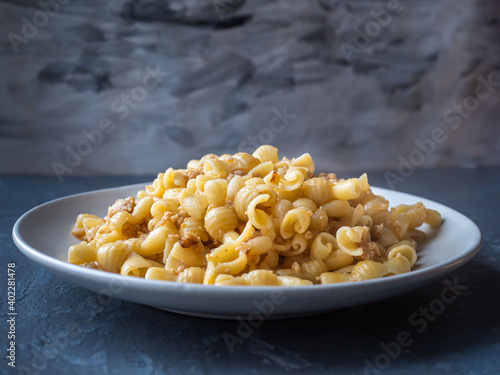 Plate with pasta and minced chicken on gray background