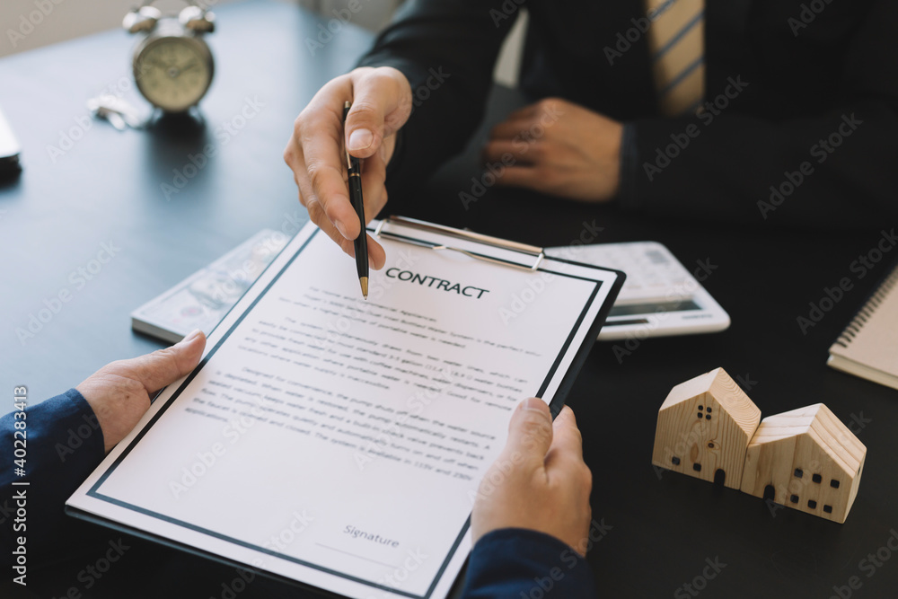 Buying a Home or Insurance, an insurance agent explains the lease agreement to a client before making a contract. Buying a Home or Insurance, an insurance agent explains the lease agreement to a client before making a contract.