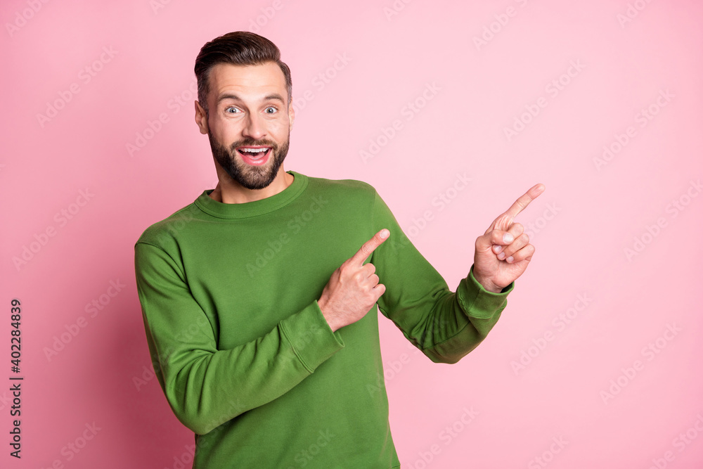 Portrait of attractive cheerful amazed guy showing copy space new offer isolated over pink pastel color background Portrait of attractive cheerful amazed guy showing copy space new offer isolated over pink pastel color background
