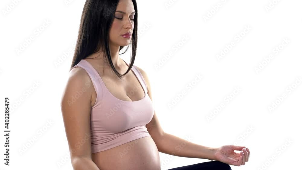 a pregnant woman sits in a lotus position and meditates on a white background a pregnant woman sits in a lotus position and meditates on a white background