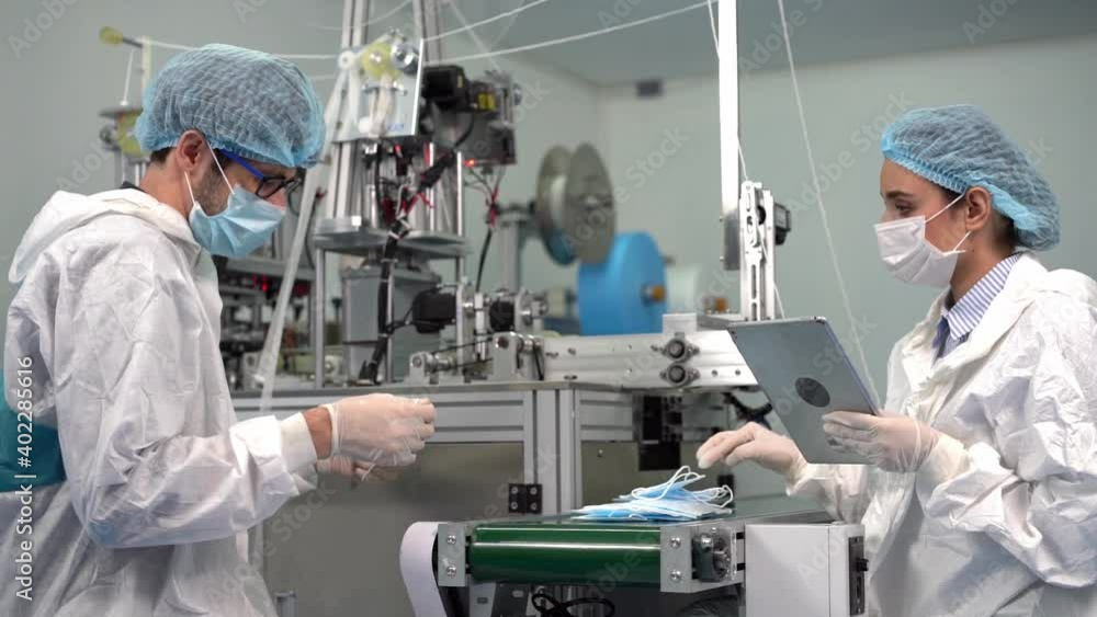 Employees and staff at the mask factory are using The tablet is a remote control to operate the machine. Employees and staff at the mask factory are using The tablet is a remote control to operate the machine.