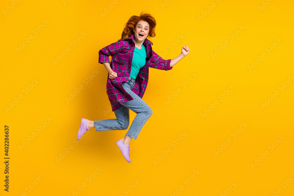 Full body portrait of crazy energetic lady jump open mouth hurry wear magenta plaid isolated on yellow color background