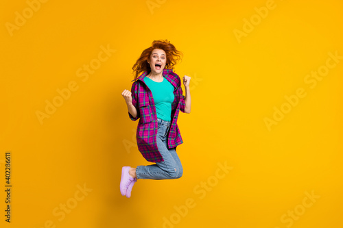Fototapeta Naklejka Na Ścianę i Meble -  Full length photo of attractive person jump open mouth fists up long purple shirt isolated on yellow color background