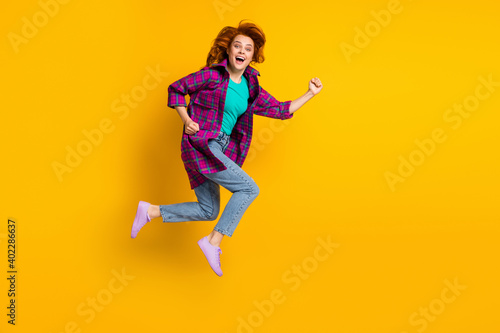 Fototapeta Naklejka Na Ścianę i Meble -  Full body portrait of crazy energetic lady jump open mouth hurry wear magenta plaid isolated on yellow color background