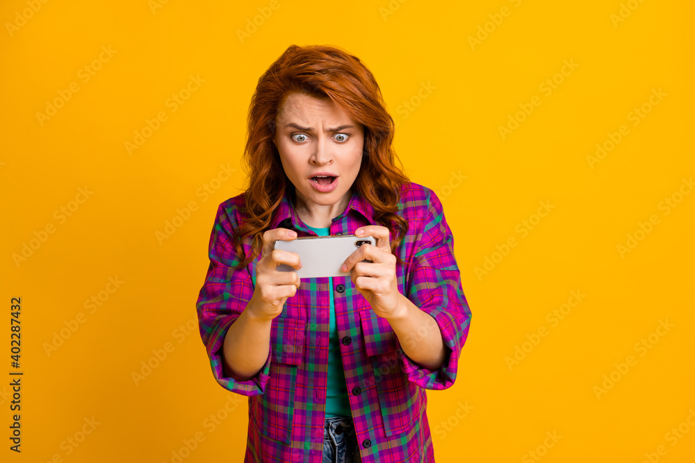 Photo of gamer person staring screen open mouth worried wear plaid magenta isolated on yellow color background Photo of gamer person staring screen open mouth worried wear plaid magenta isolated on yellow color background