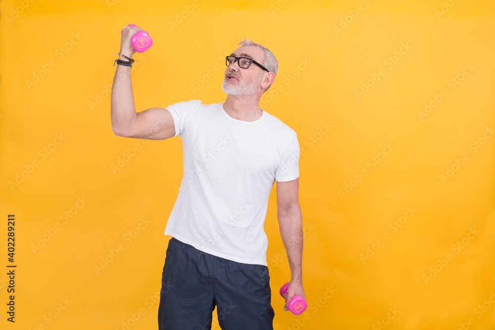 attractive mature man doing sports and showing muscle with dumbbells