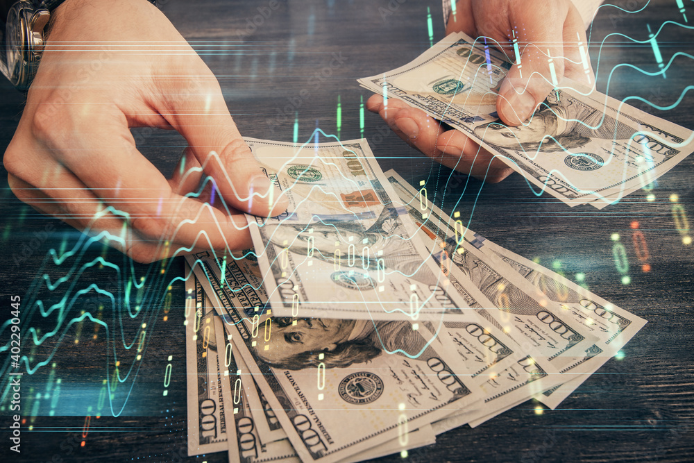 Multi exposure of financial graph drawing hologram and USA dollars bills and man hands. Analysis concept. Multi exposure of financial graph drawing hologram and USA dollars bills and man hands. Analysis concept.
