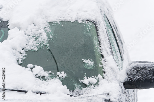 suv Car is all covered with snow at winter morning in country side. Concept of driving in winter time with snow on road.