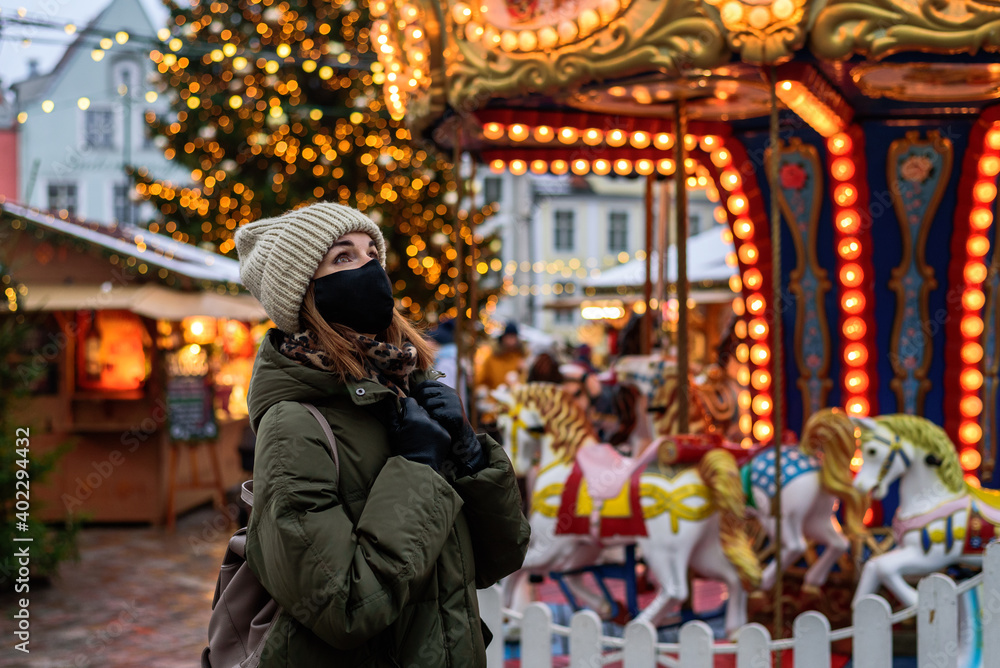 Woman in face mask on Christmas market in Tallinn, Estonia