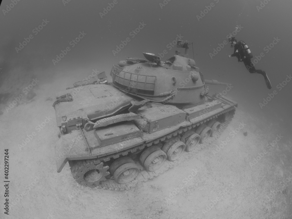 scuba diver exploring tank wreck underwater scuba diver exploring tank wreck underwater
