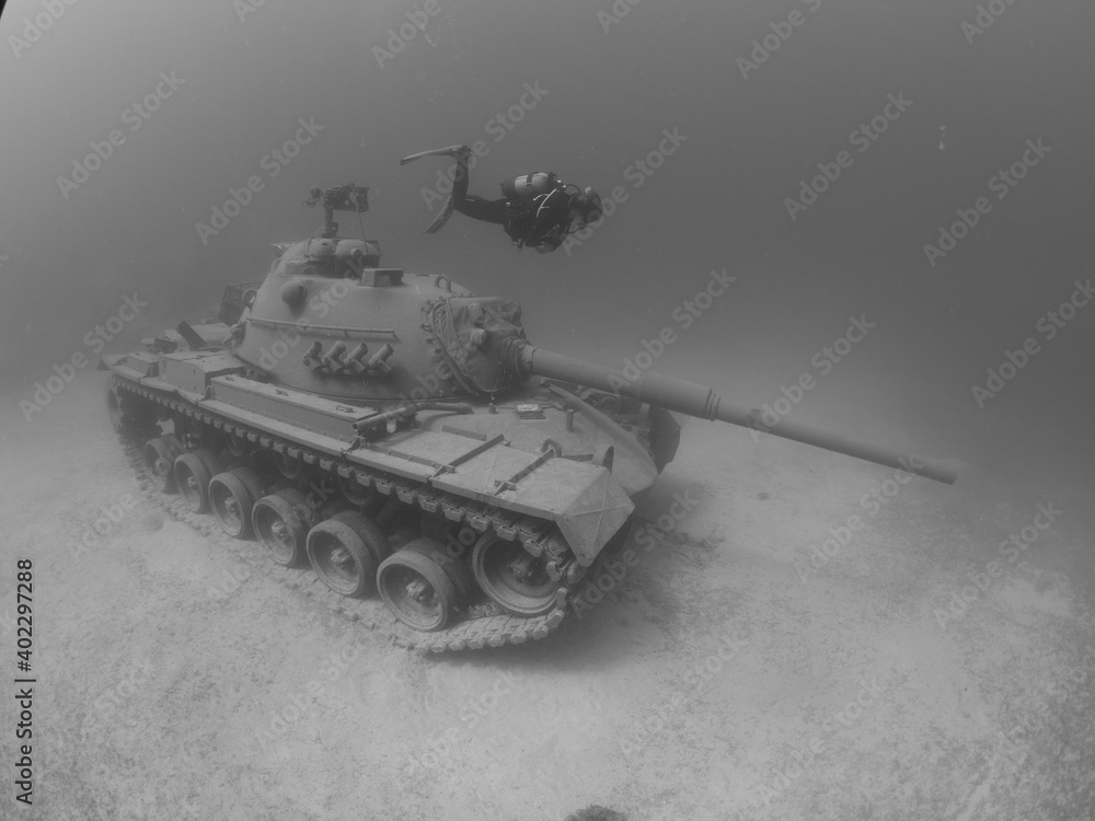 scuba diver exploring tank wreck underwater scuba diver exploring tank wreck underwater
