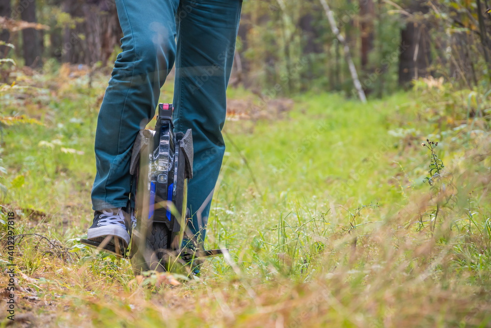 Obraz premium Front view of men's legs on an electric unicycle