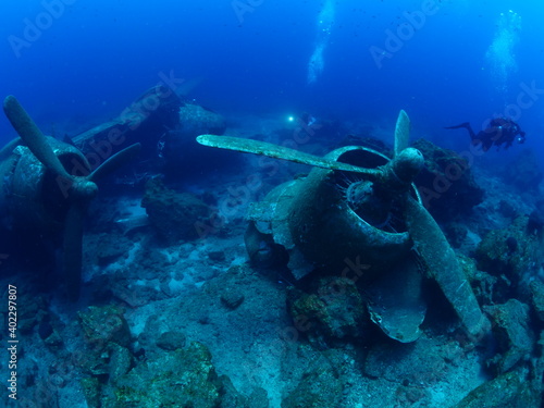 scuba divers exploring airplane wreck underwater taking photos of c47 dakota airplane engine  © underocean