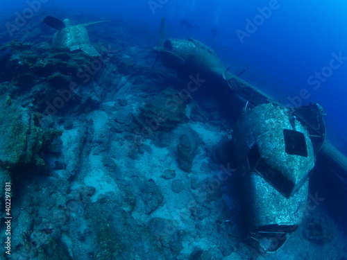 Fototapeta Naklejka Na Ścianę i Meble -  scuba divers exploring airplane wreck underwater taking photos of c47 dakota airplane engine 