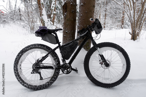 Extreme sport. Bikepacking in the winter forest. Fat bike with studded winter tire. 