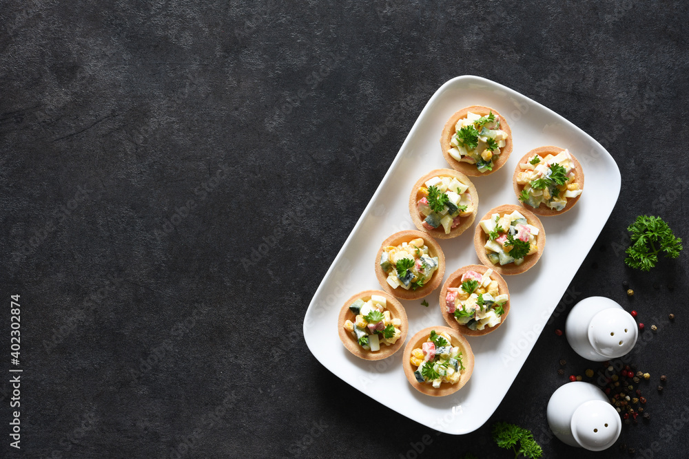 Tartlets with salad, carab meat and corn on the kitchen table with space for the text. Tartlets with salad, carab meat and corn on the kitchen table with space for the text.