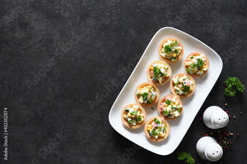 Tartlets with salad, carab meat and corn on the kitchen table with space for the text. photo