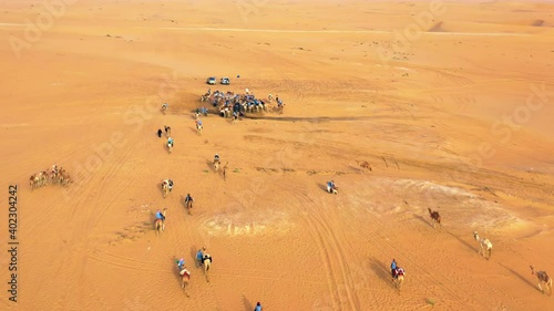 Aerial drone view of a camels and thirsty people gathered to drink, at a water well in Sahara, Africa