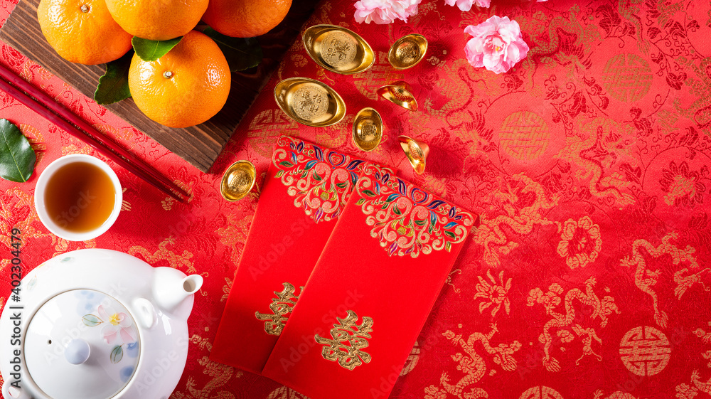 Chinese new year decorations, pow or red packet, orange and gold ingots on red background. Chinese characters FU in the article refer to fortune good luck, wealth, money flow.