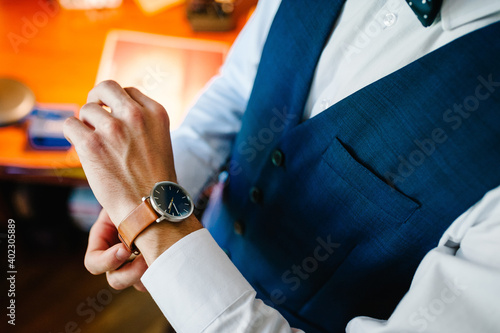 A man in a shirt adjusts the watch on his arm. Close up of businessman using watch. flat lay. top view.