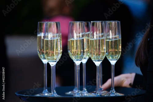 woman carrying tray of champagne glasses