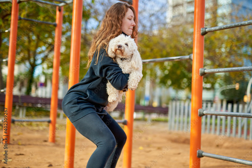girl doing exercises with a dog in her hands girl doing exercises with a dog in her hands
