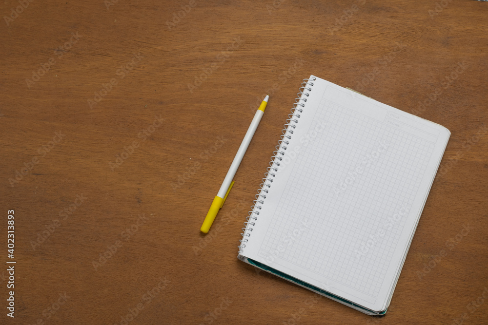 Notebook without writing next to pen on wooden table Notebook without writing next to pen on wooden table