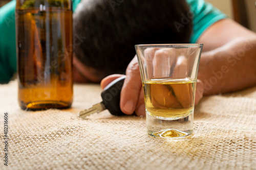 man with car key and glass of alcoholic drink on the table. if you drink do not drive photo