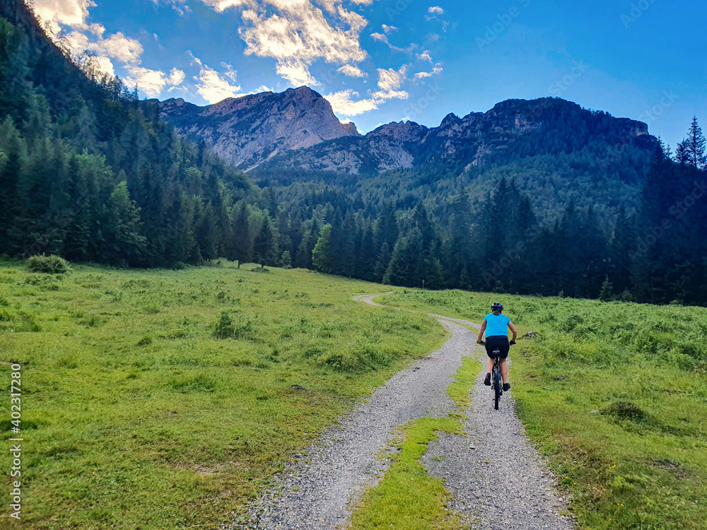 COPY SPACE: Unrecognizable fit woman rides a mountain bike along a hiking trail.