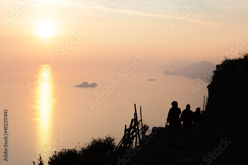 Silhouette Of People walking along the path of the gods in a spectacular sunset over the sea. Amalfi coast   island of Capri  Campania  souther Italy.