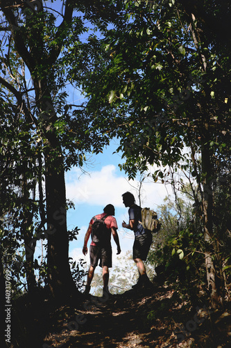 Two young escurionists walk along a trail of the Conway National Park, Airlie beach, Australia.